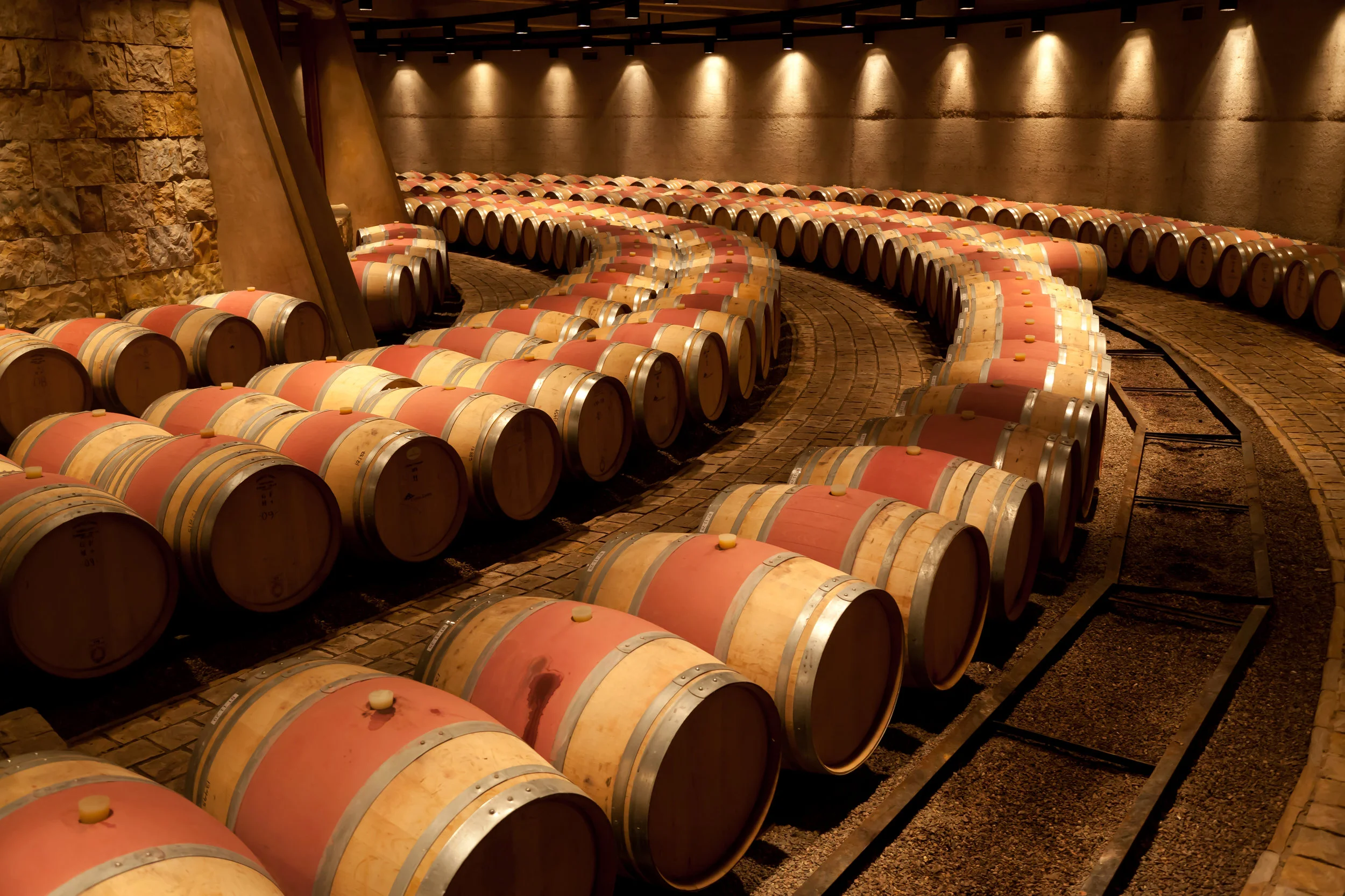 Illuminated wine cellar with bottles racked floor to ceiling